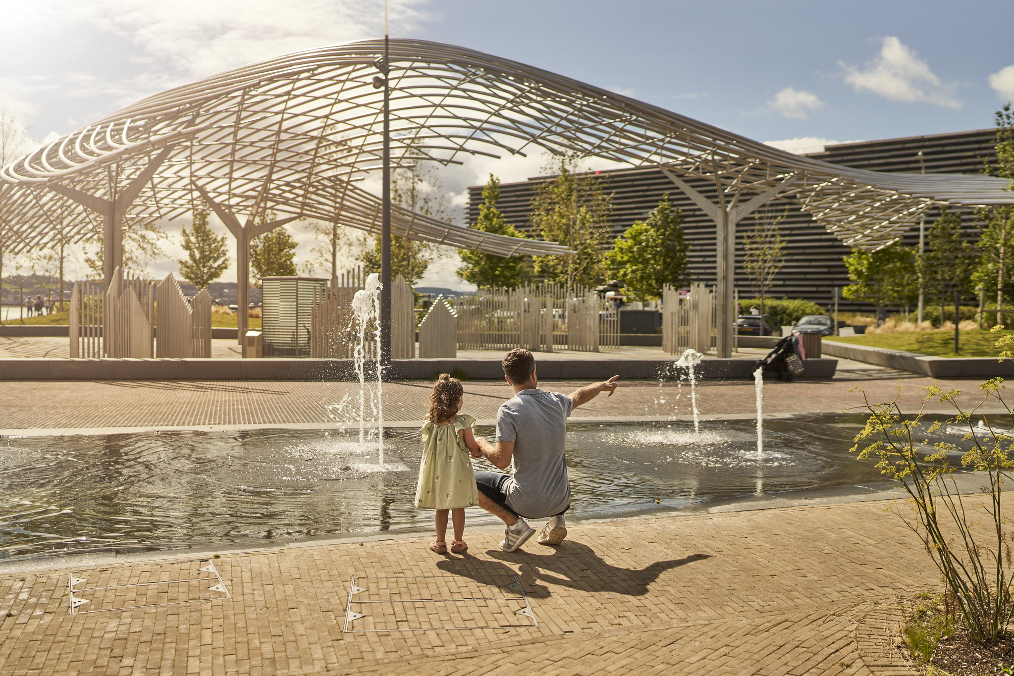 Man and child at water feature