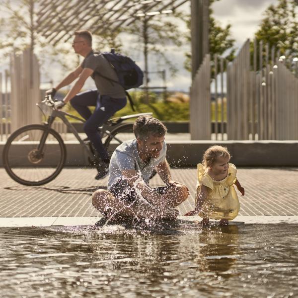 Man and little girl fountains waterfront